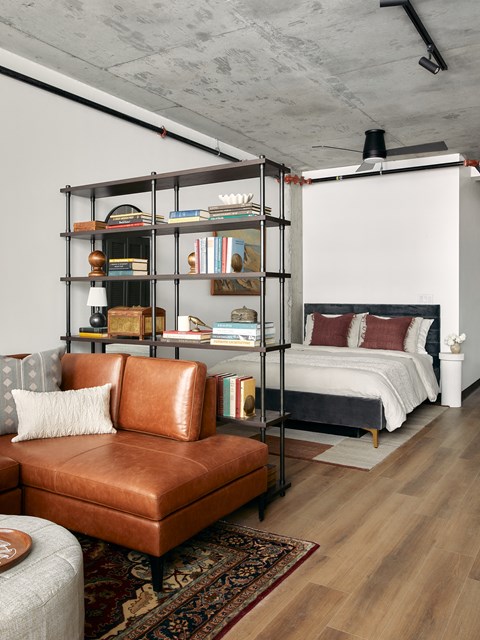 a bedroom with a bed and a bookshelf in a loft